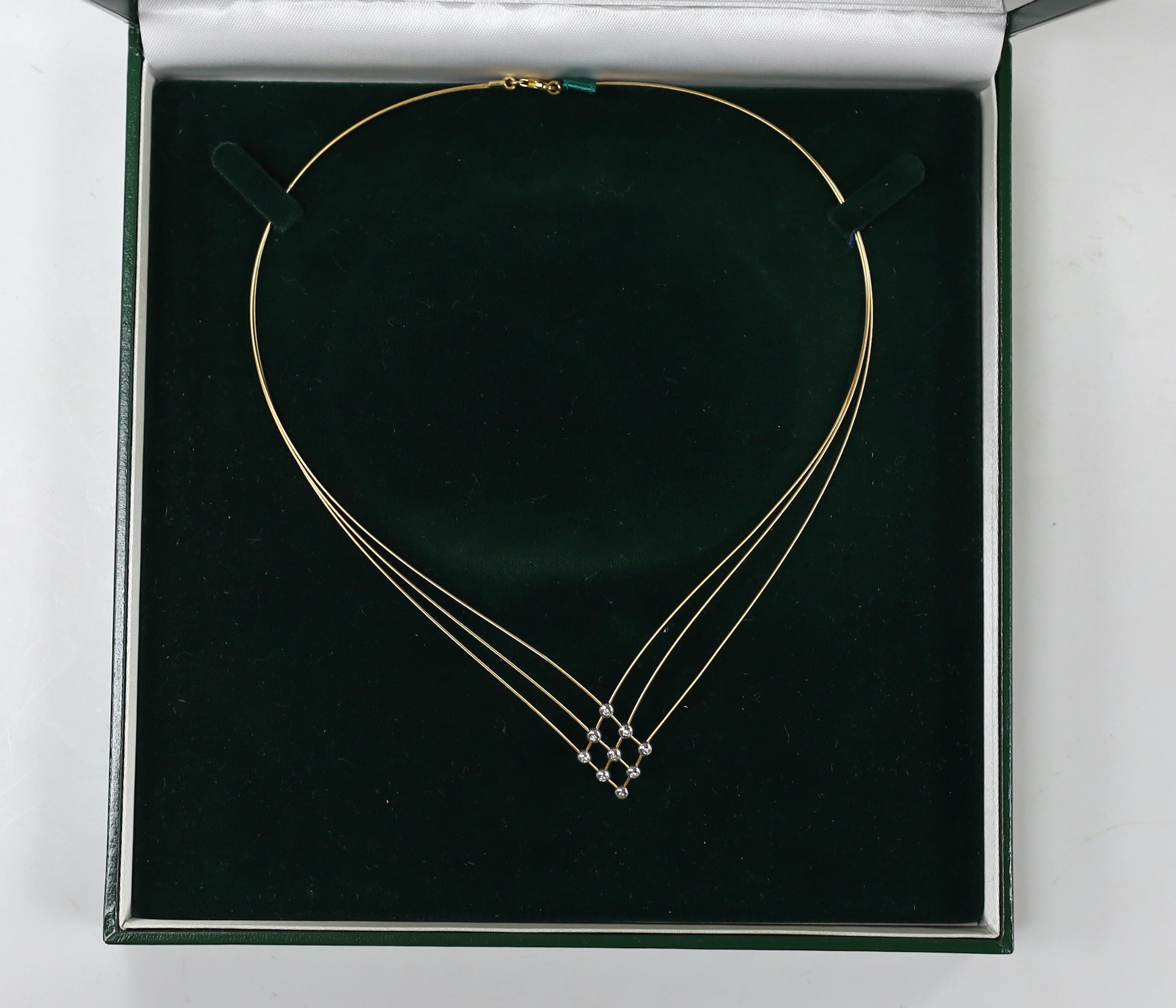 A boxed modern 18ct gold and nine stone diamond chip set triple fine strand necklet, approx. 42cm, gross weight 6 grams.